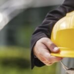 Engineer. Engineer holding protective helmet closeup shot